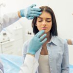 Woman sitting in a doctor's office with her face being examined